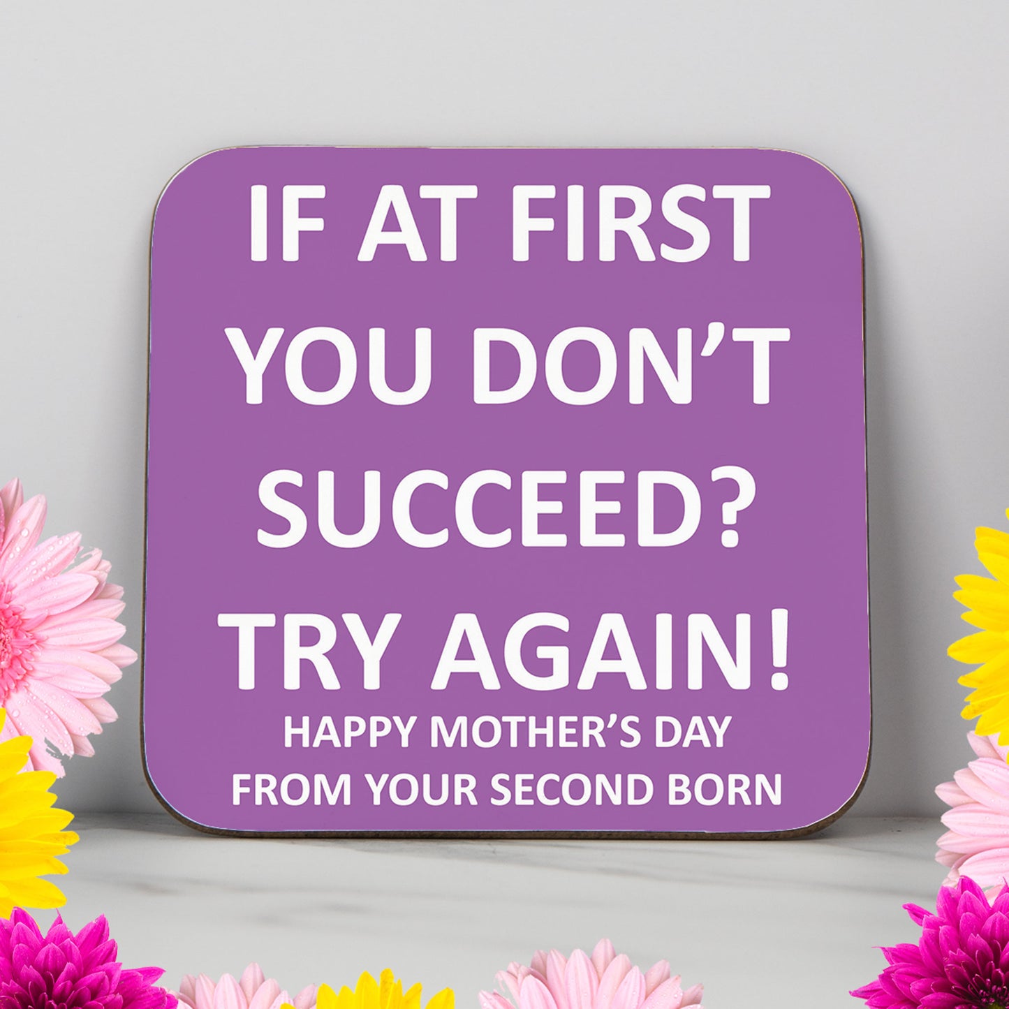 Funny Mother’s Day coaster with bold quote: "If at first you don't succeed? Try again! Happy Mother’s Day from your second born." Glossy purple coaster with white text, perfect for mums with a great sense of humour. Ideal gift from second-born son or daughter. Great for adding a light-hearted touch to Mother’s Day. Printed in the UK on a wipe-clean surface. A fun and unique keepsake gift for mum from her second child.